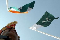 An Indian border guard stands near Indian and Pakistani flags during a fair in Chamliyal in the northern Indian state of Jammu and Kashmir