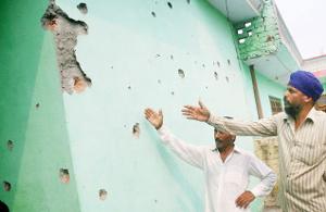 An April 2014 file photo of villagers showing bullet marks on the wall of a house after firing from Pakistan side in Devigarh village at the India-Pakistan International border at Arnia sector in Jammu [File Photo]