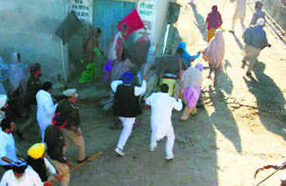 Policemen and SAD workers chase away farmers at Kothaguru village on Tuesday