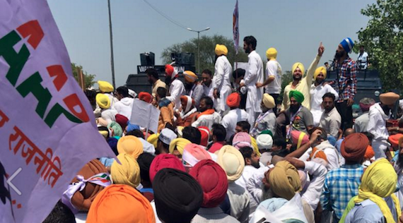 AAP activists climb over the barricades