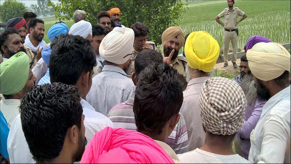 A police officer interacting with Sikh representatives