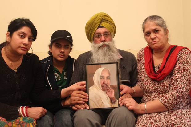 Gurmej Singh and his family holds up a picture of 78-year-old Harbhajan Kaur