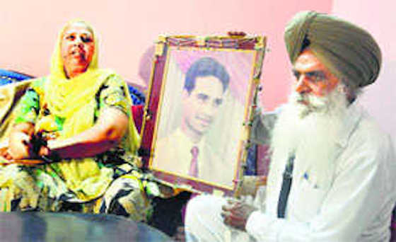 Charanjit Kaur and Amrik Singh with picture of their son Avtar Singh, who was allegedly killed by Gurmeet Pinki